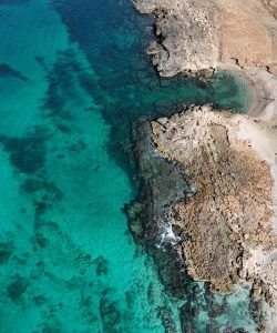 aerial view of rocky coastline and crystal-clear turquoise waters in Sal Island, Cape Verde